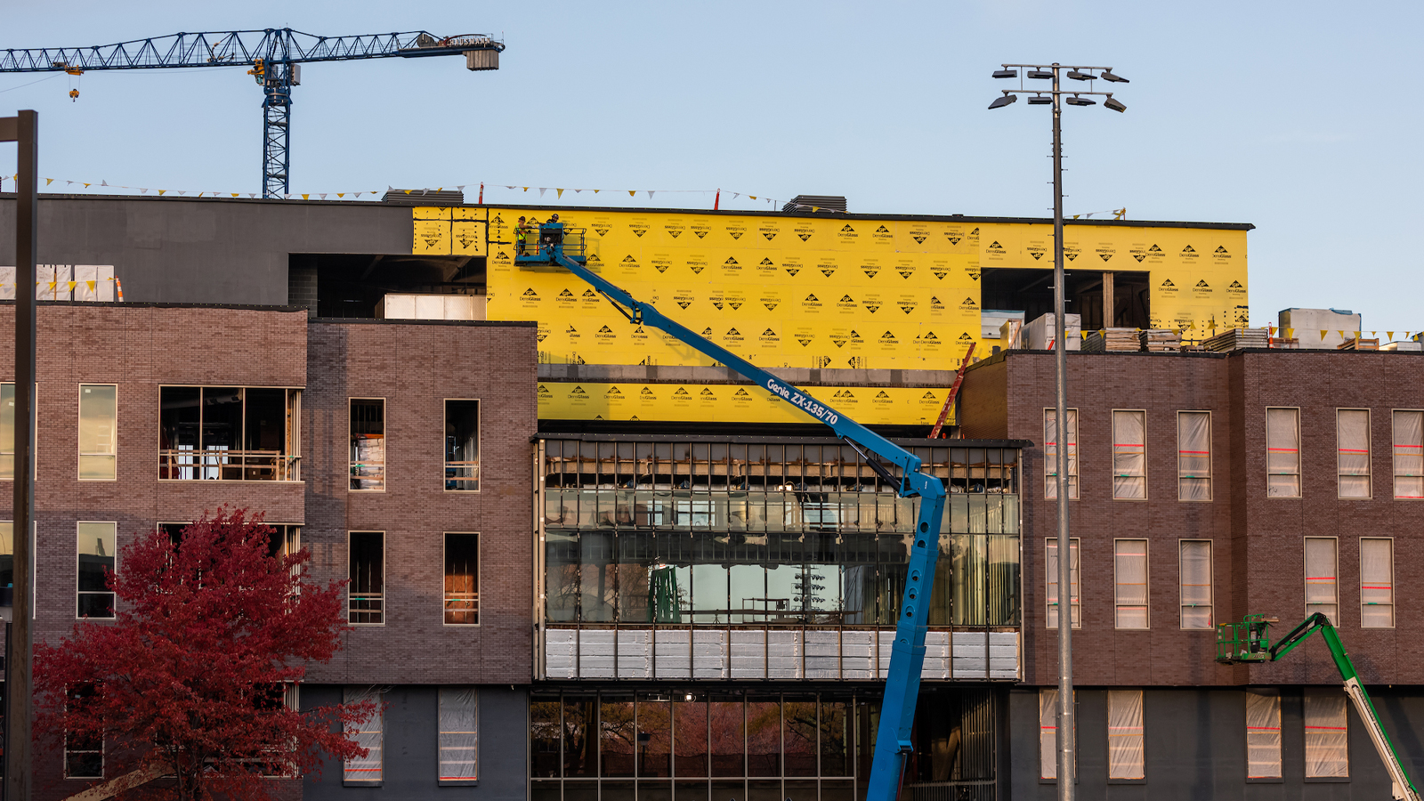 Workers affix insulation panels on the new College of Education and Human Sciences building