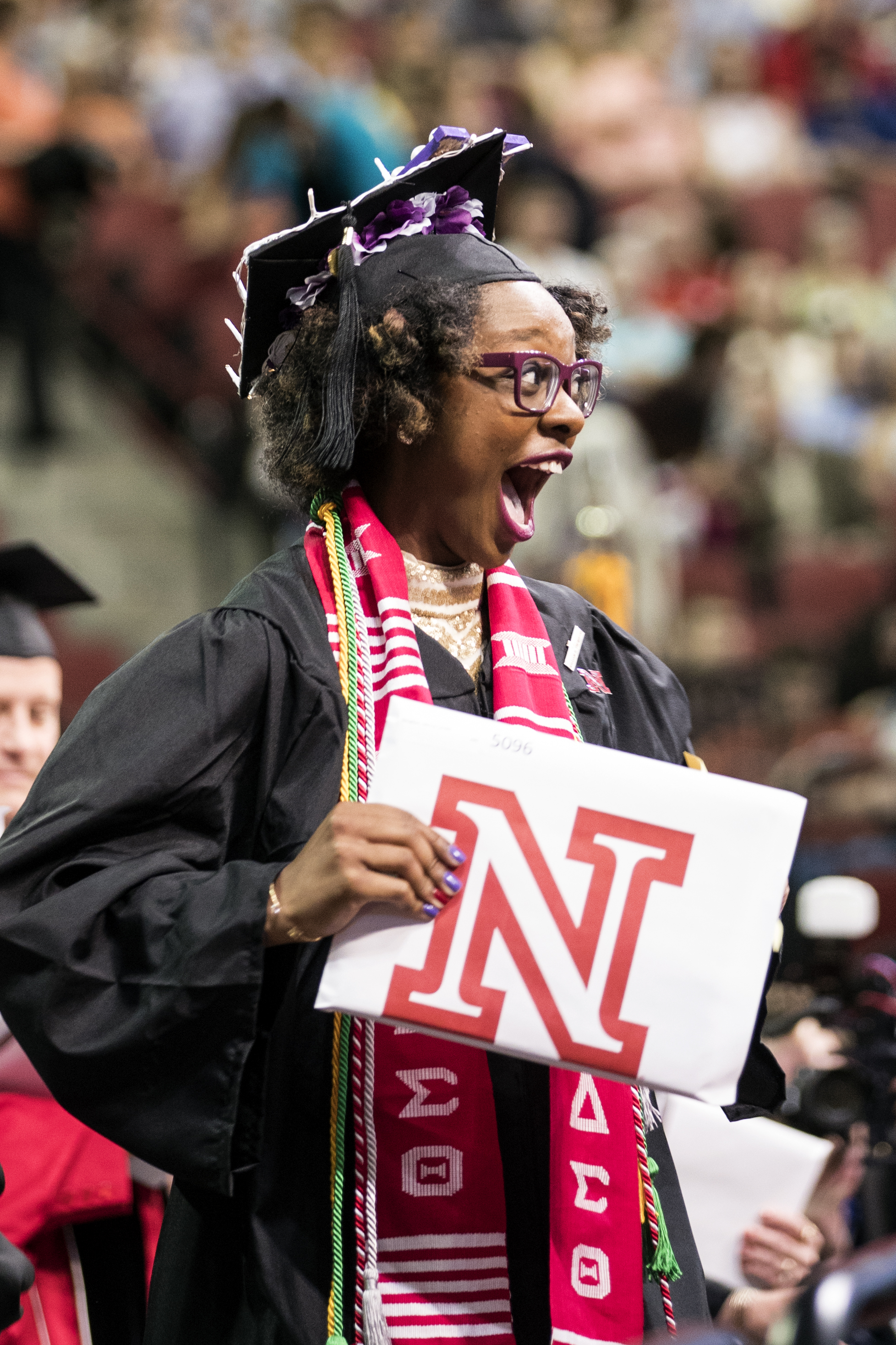 Mecca Slaughter, who earned a bachelor of journalism, celebrates as she walks off stage during the undergraduate commencement ceremony.