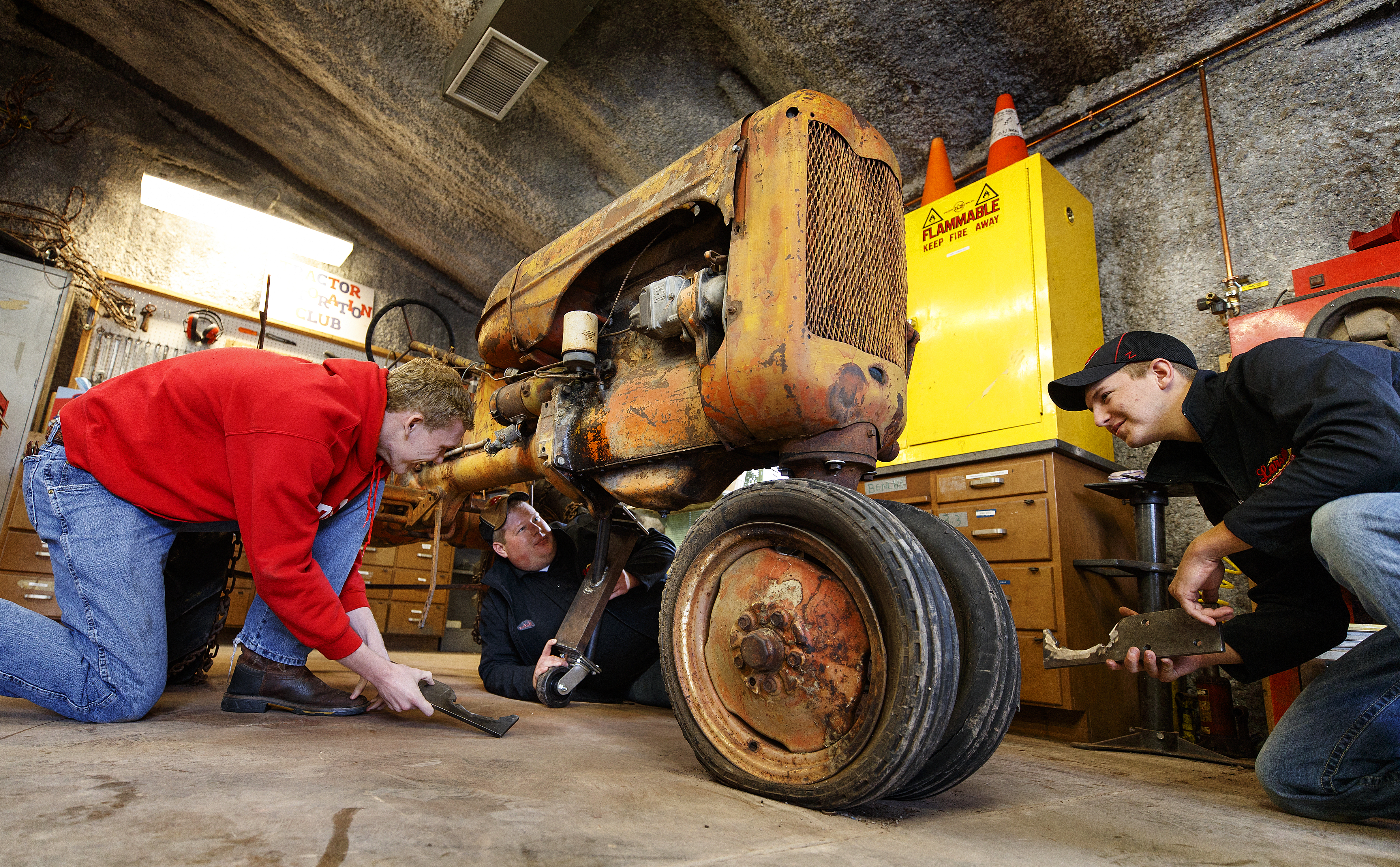 Tractor Restoration Club members (from left) Kiel Kruse, Joshua Bauer and Jaythan Scheideler work with support pieces that will be attached to the 1945 Allis Chalmers Model C so it can be moved around for restoration work. Club members are preparing the tractor for display at the Homestead National Monument of America near Beatrice.