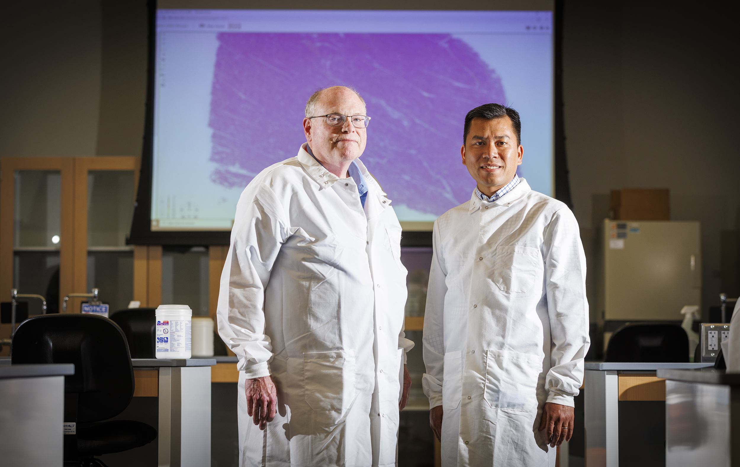 Scott McVey and Hiep Vu stand in a lab