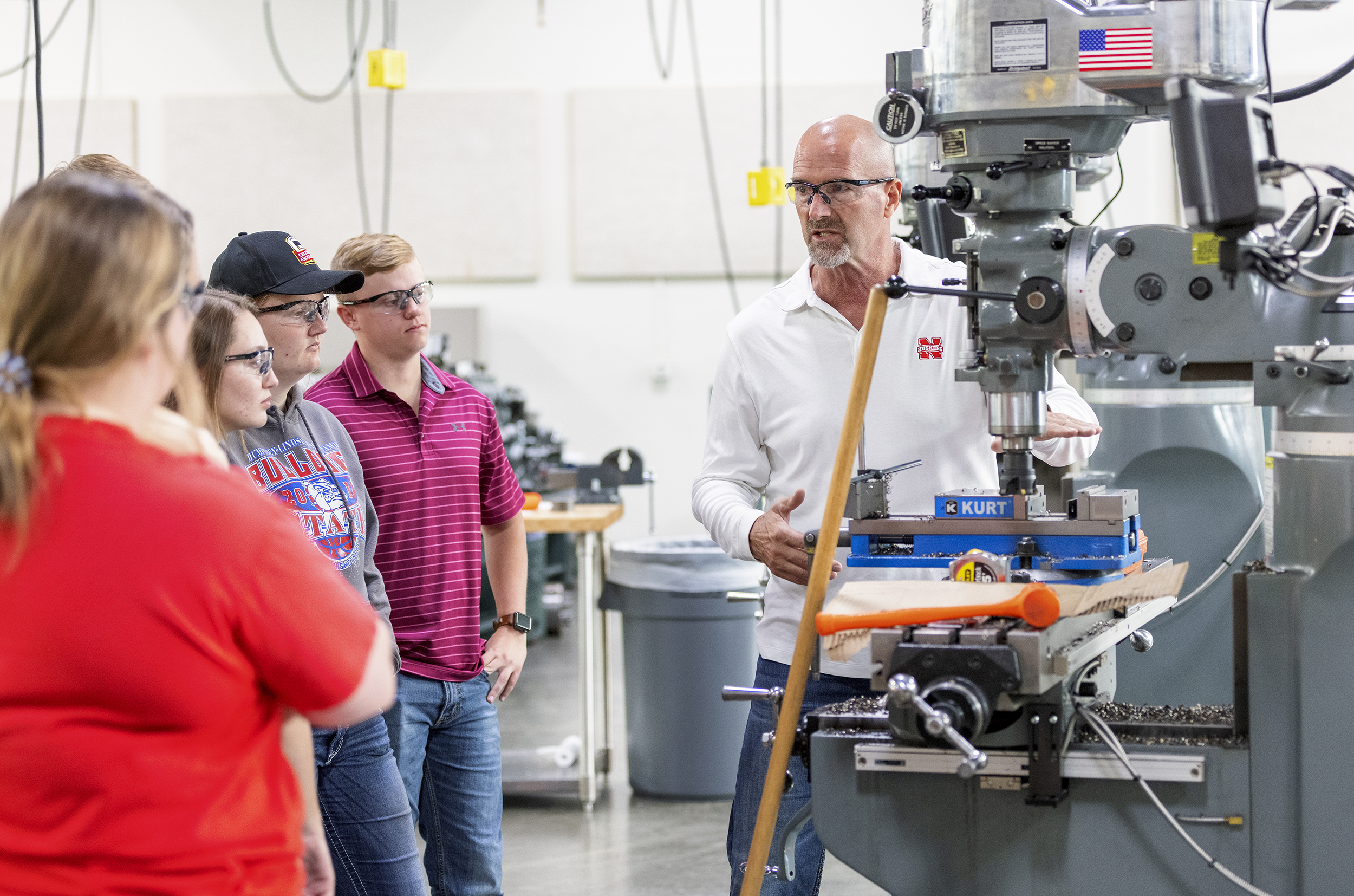 Eric Knoll stands next to several students, with everyone wearing safety glasses