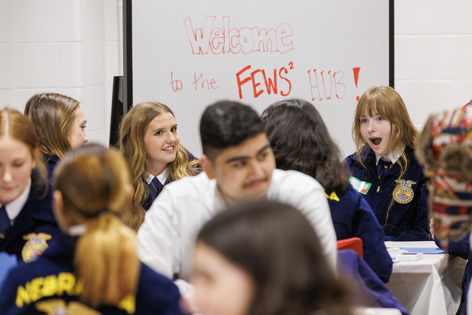 Nebraska FFA members sit at tables.