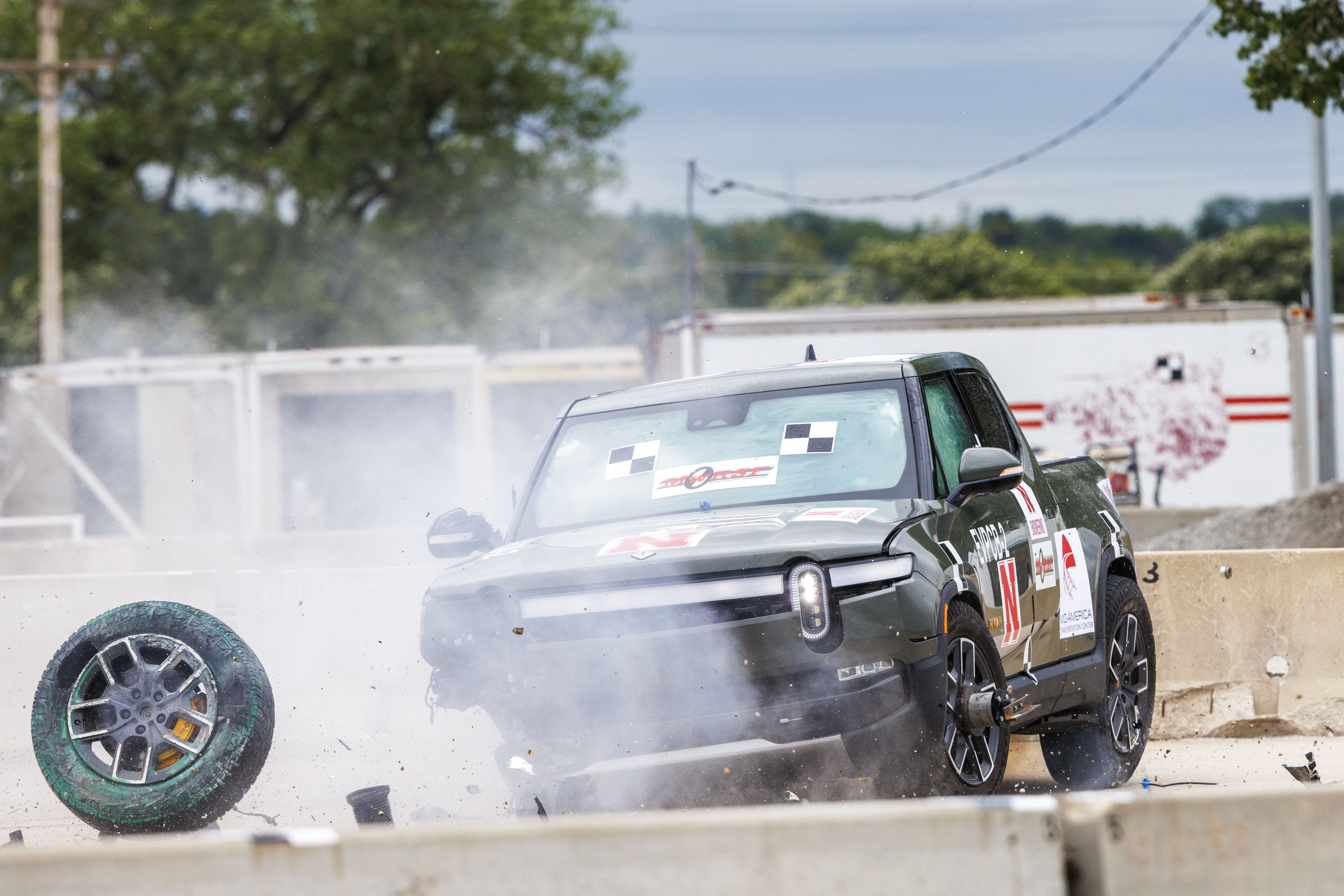 A Rivian electric vehicle spins out after striking a barrier.