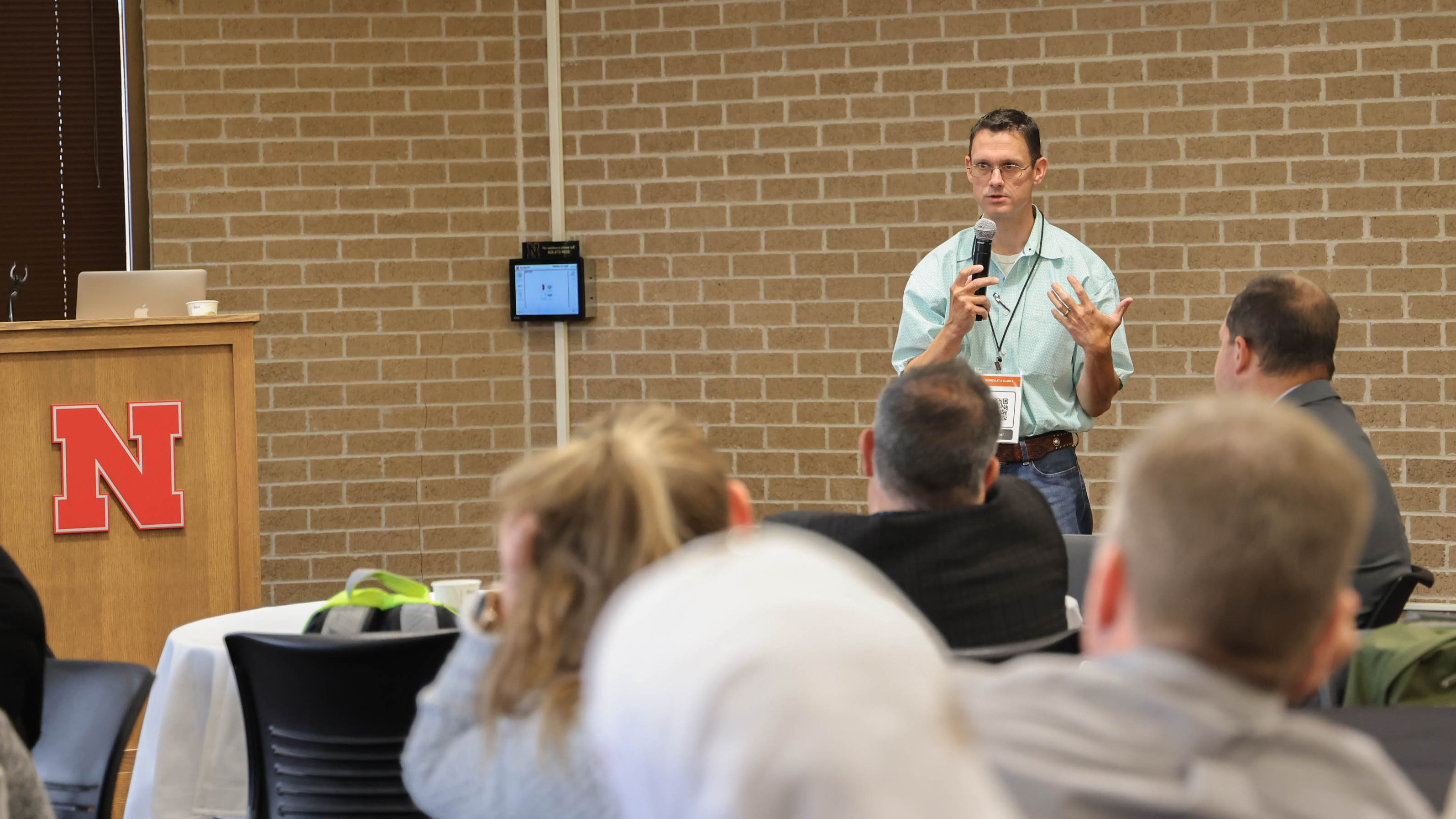 Matt Spangler uses a microphone to speak to a small crowd.