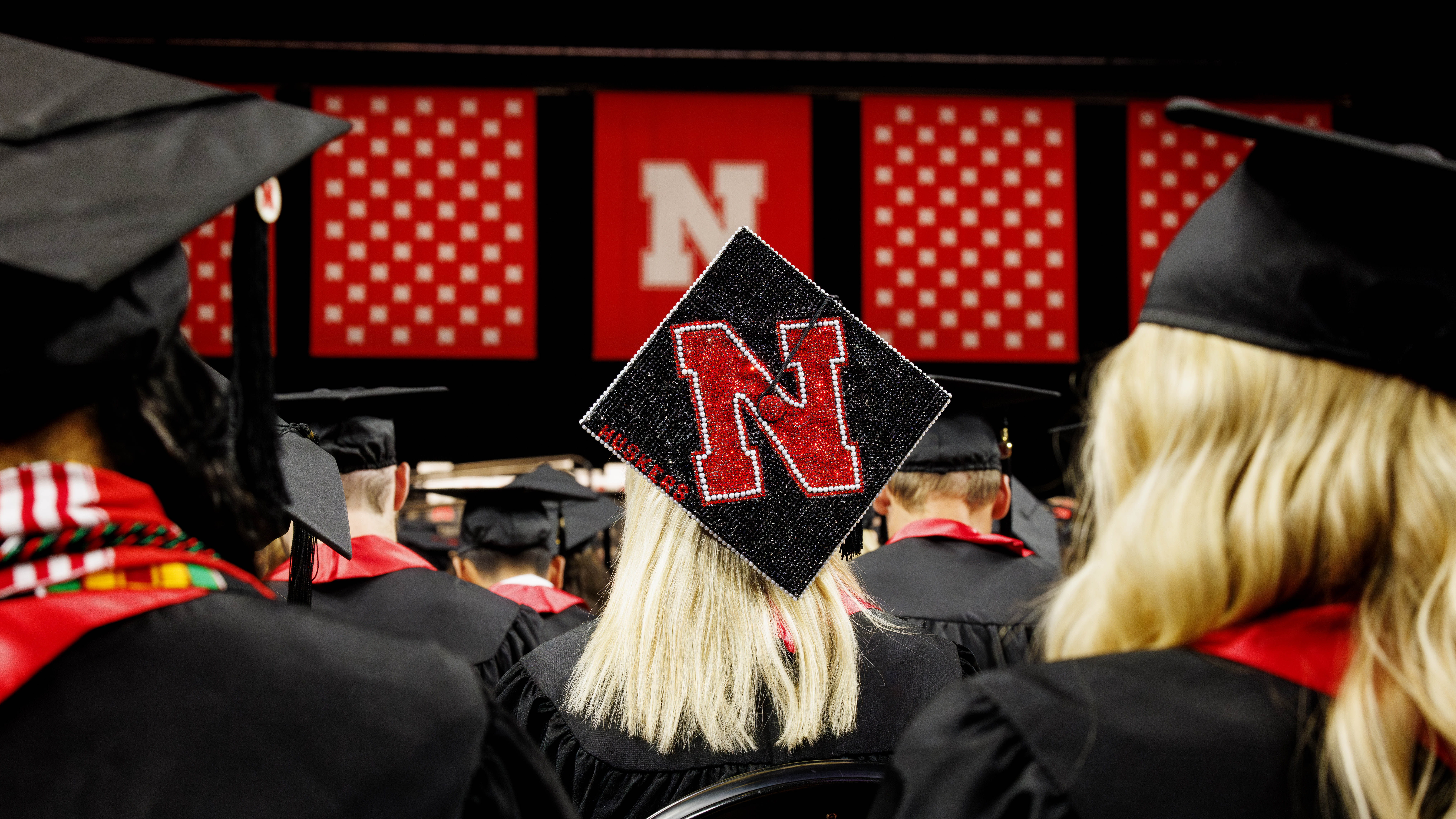 A female graduates bedazzled Nebraska N mortar board stands out in Pinnacle Bank Arena.