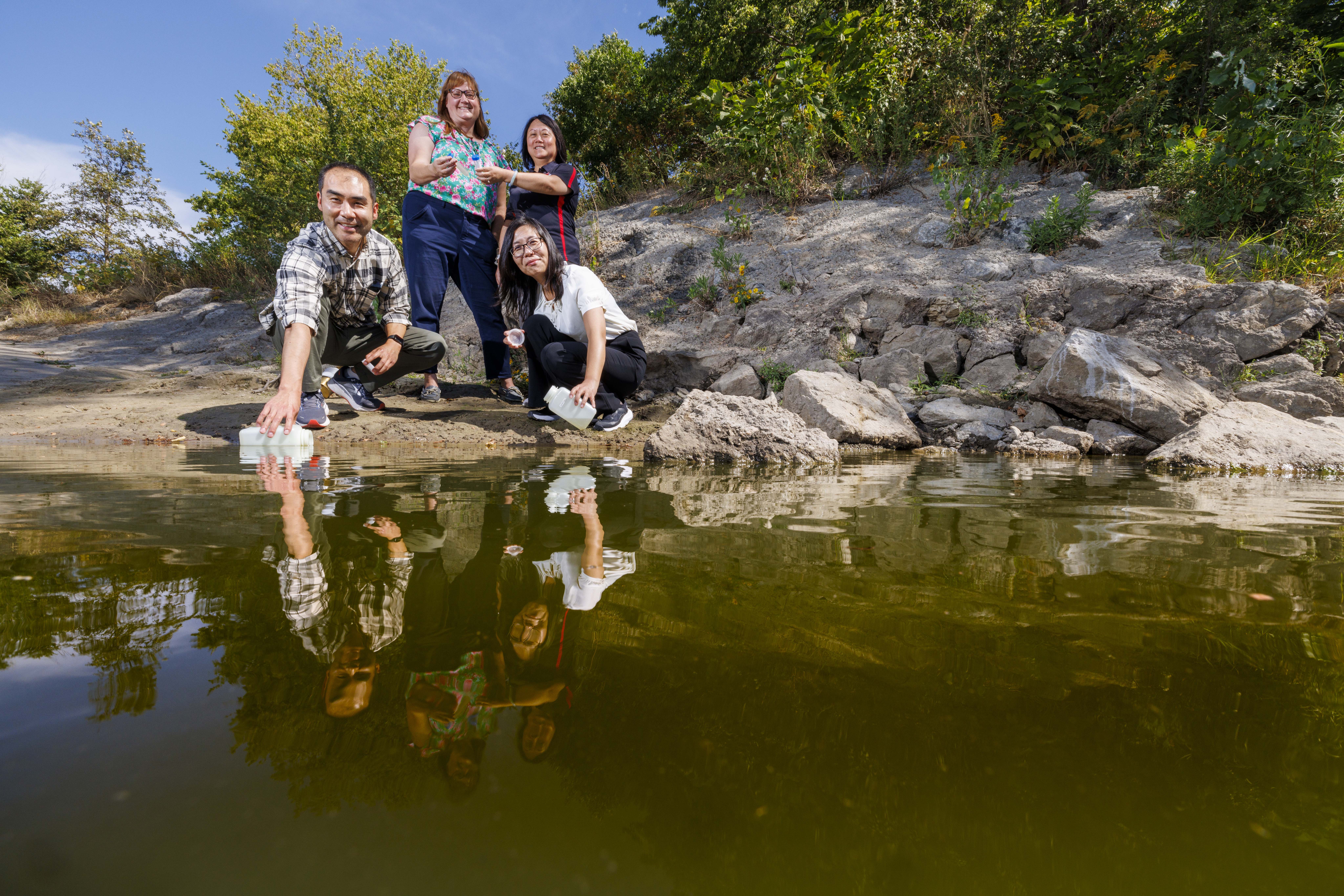 Xu Li (front left), Bing Wang (front right), Shannon Bartelt-Hunt (back left) and Yusong Li (back right) collect and examine water samples from the Elkhorn River near Waterloo, Nebraska.