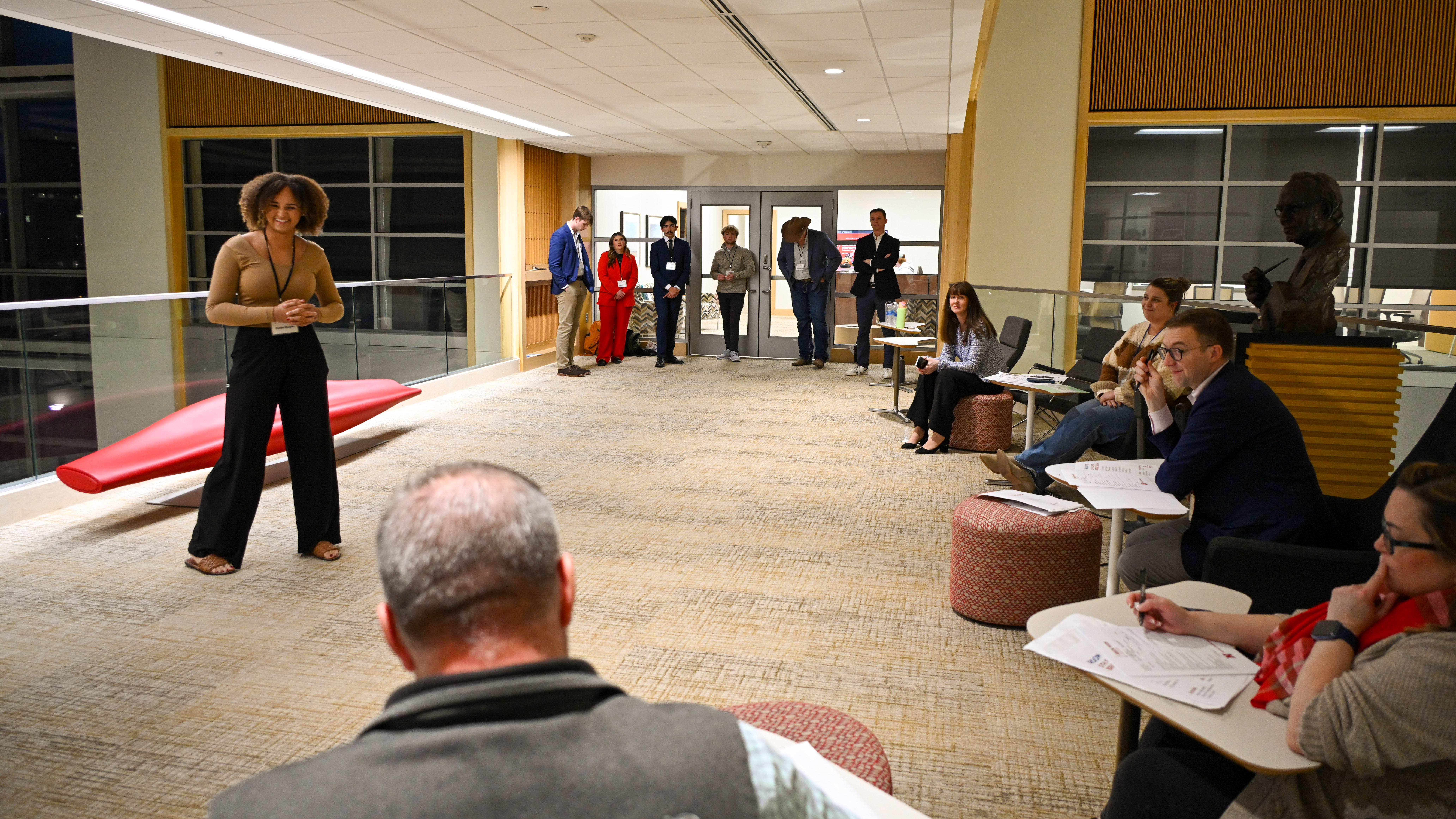 Kylee Magee speaks to a panel of judges during the 3-2-1 Quick Pitch competition as fellow competitors wait in the background.