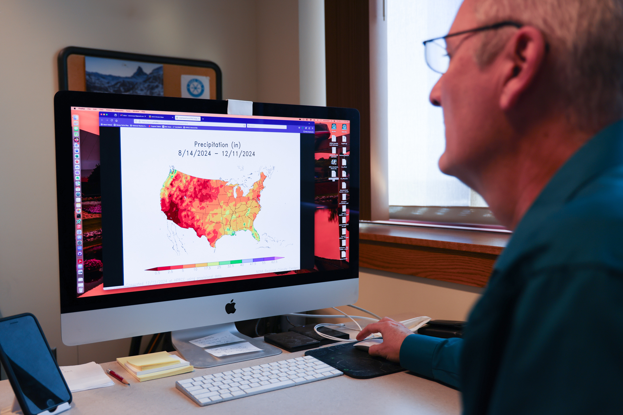 Bill Sorensen, senior applications/systems programmer for the High Plains Regional Climate Center, reviews an Applied Climate Information System map showing precipitation levels throughout the country during the last four months.