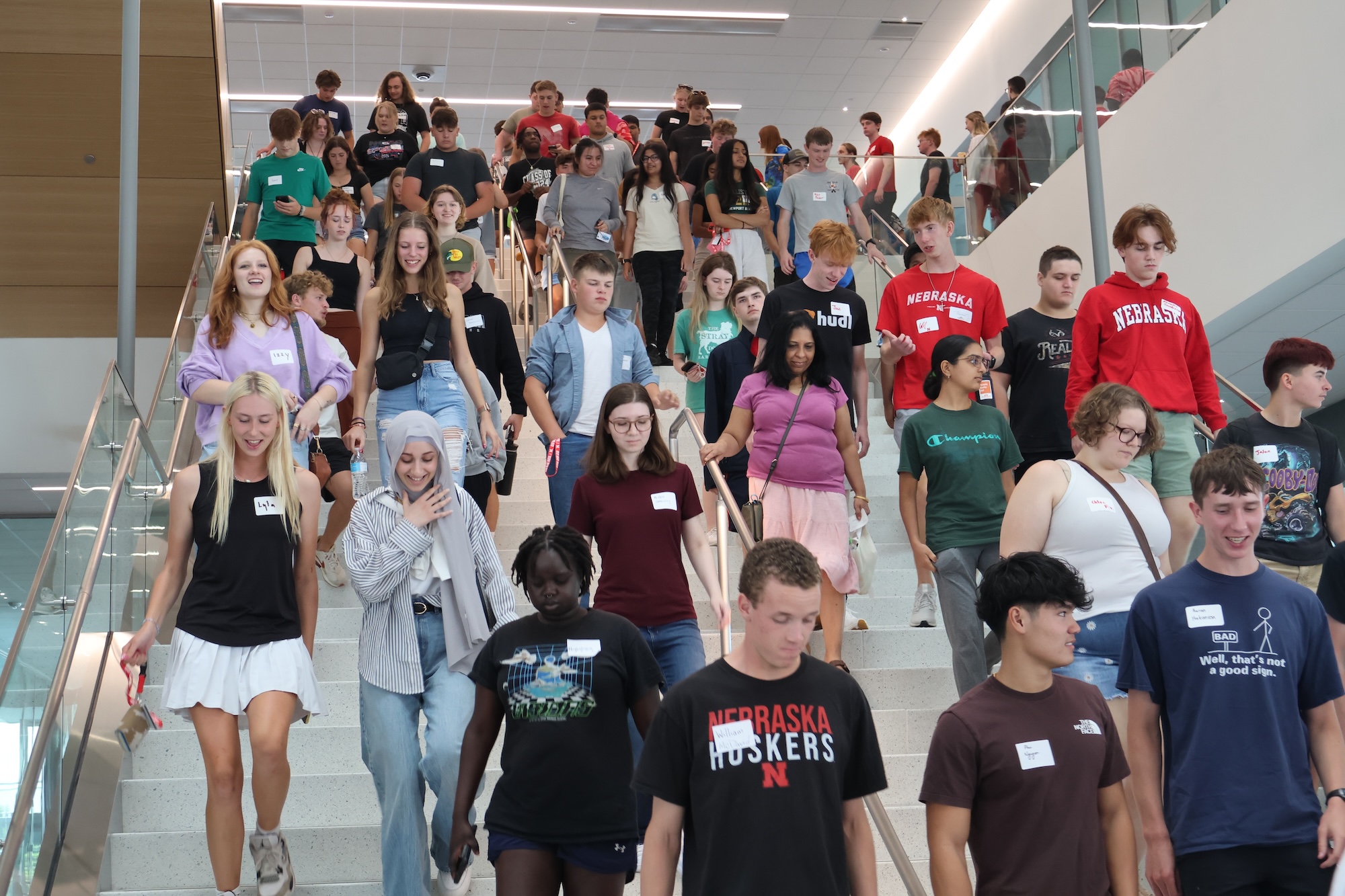 Dozens of Nebraska Engineering students walk down a staircase in Kiewit Hall.