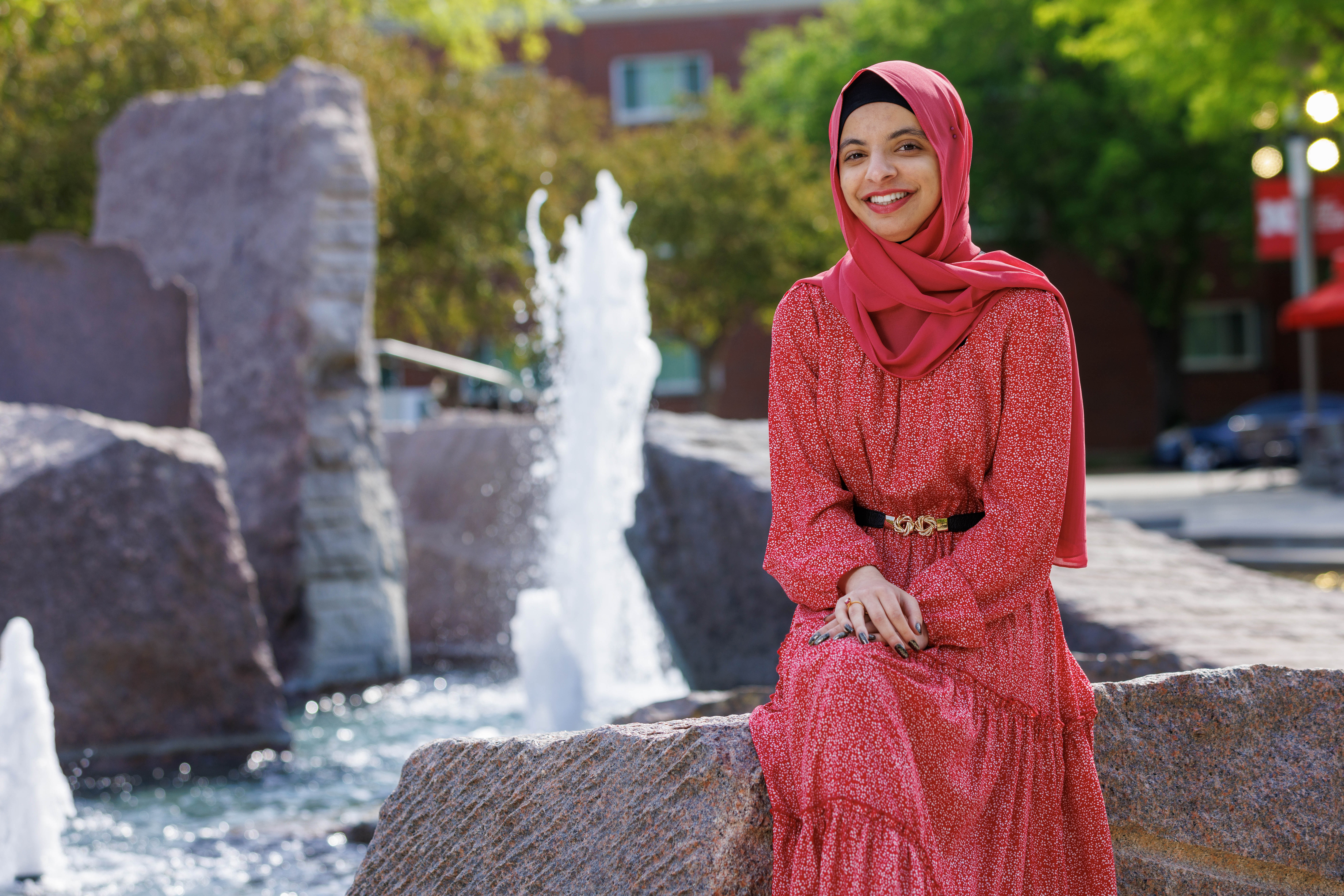 A color portrait of Sukaina Al-Hamedi next to Broyhill Foundation on the University of Nebraska–Lincoln's City Campus.