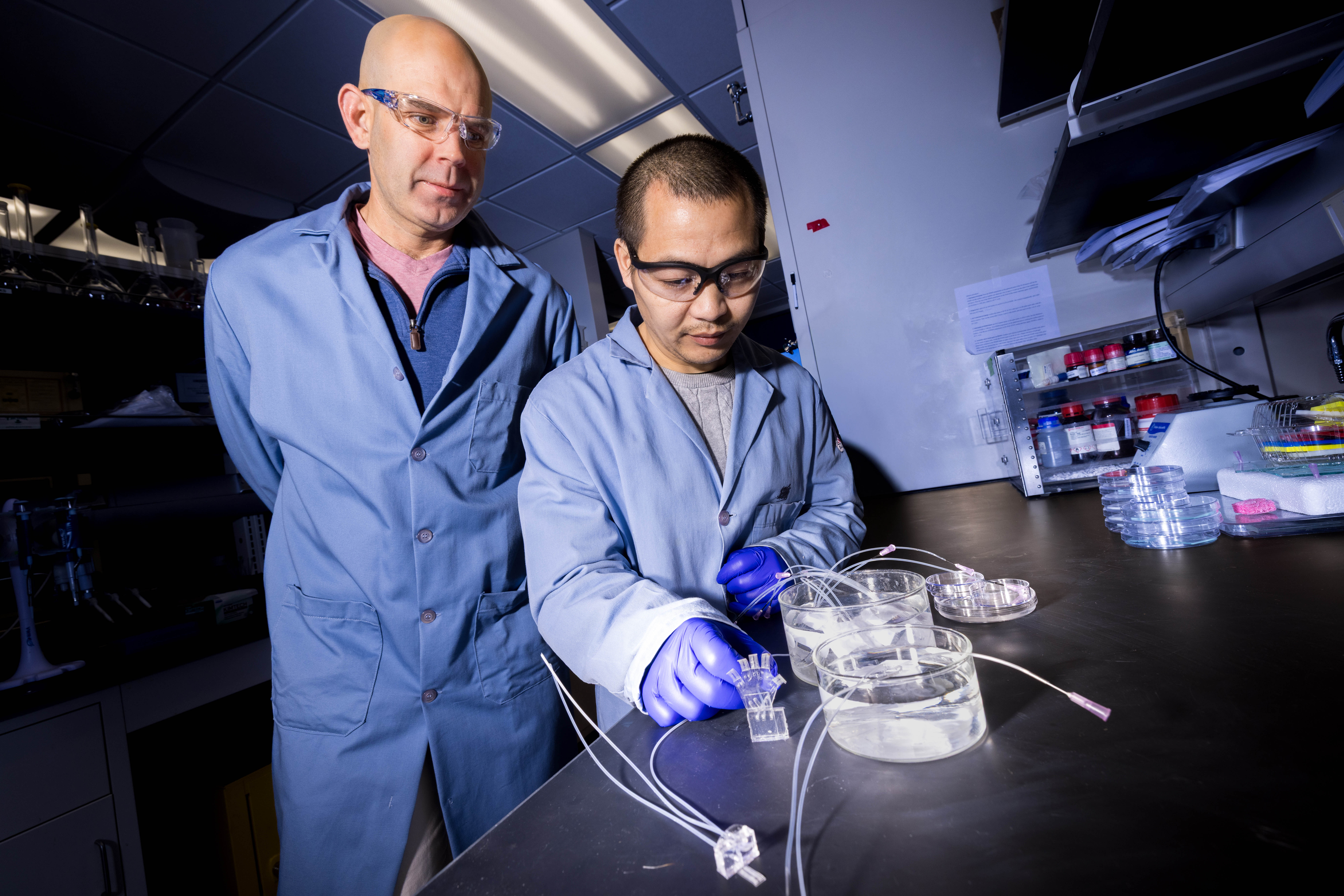 Stephen Morin (left), associate professor of chemistry, and Nengiian Huang, a graduate student in chemistry, pose for a photograph in a lab.