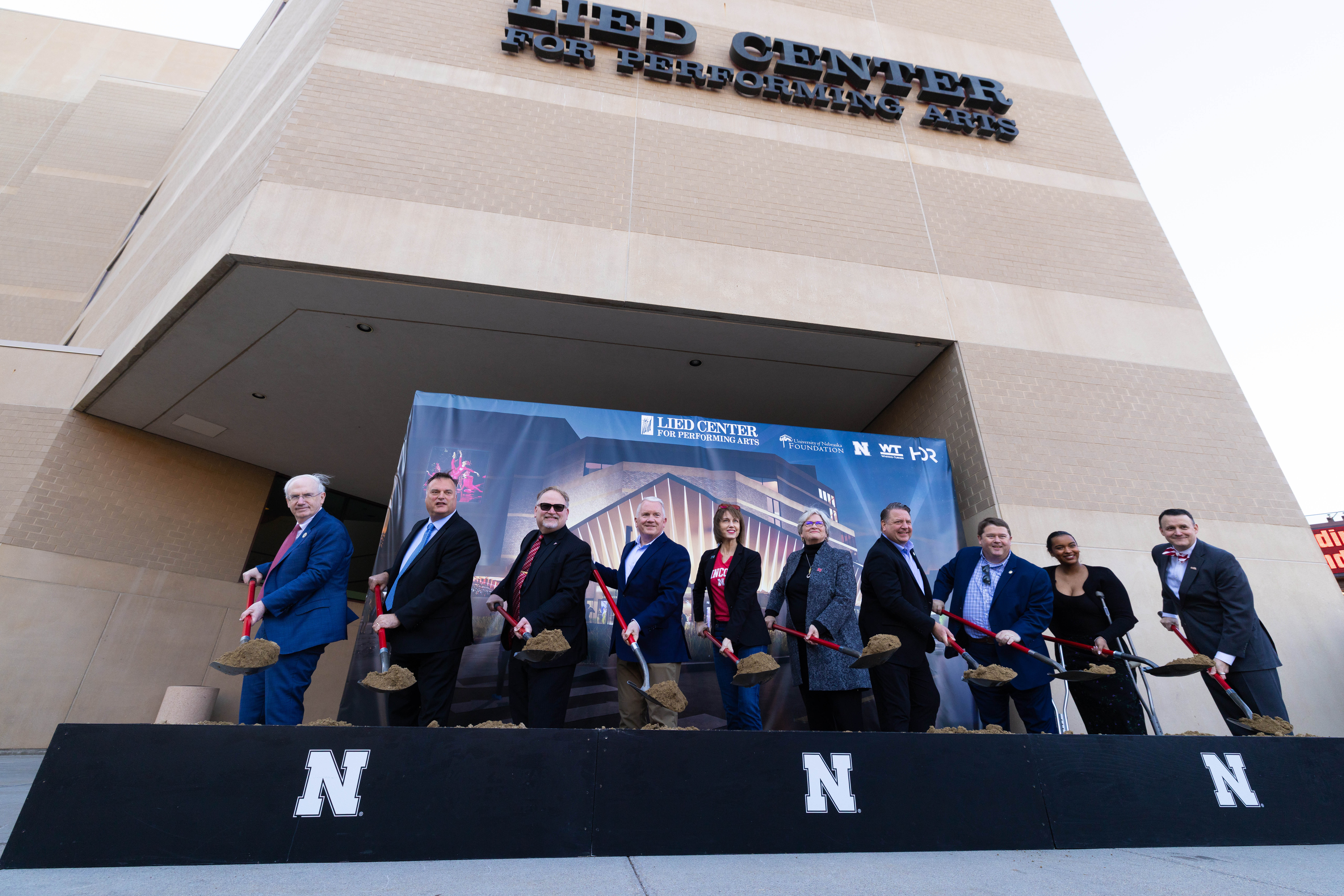 Dignitaries from the University of Nebraska and the City of Lincoln — eight women and five men — hold shovels of dirt during a groundbreaking ceremony outside of the Lied Center for Performing Arts. participate in a groundbreaking ceremony outside of the Lied Center for Performing Arts. The ceremony celebrated the start of the "Building the Future" project — a $35 million privately funded addition and renovation project at the venue.