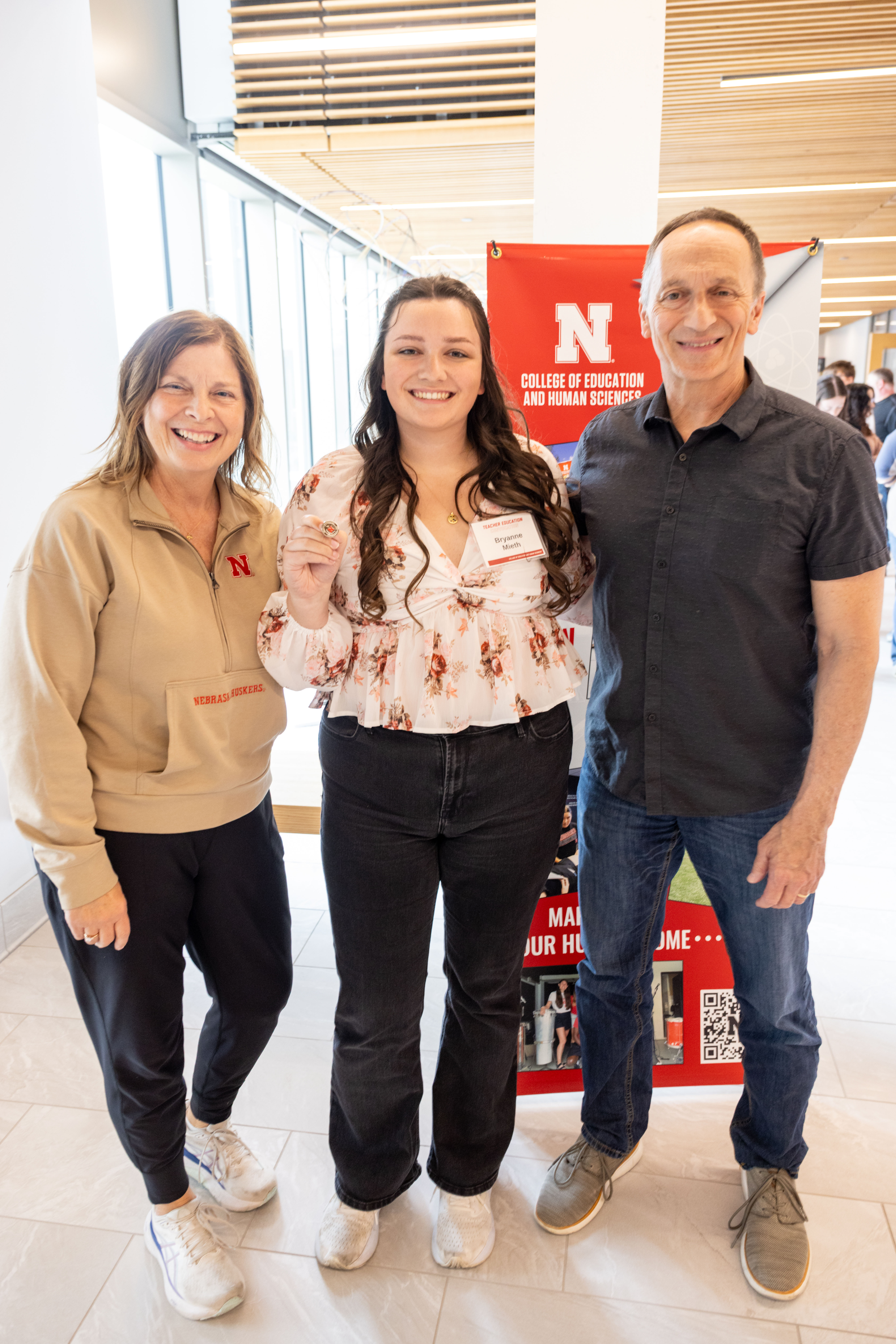 Bryanne Mieth (center), an elementary education major from Lincoln, holds her pin while posing for a photo with her parents, Carla (left) and Bruce (right), after the Teacher Education Convocation on April 17.