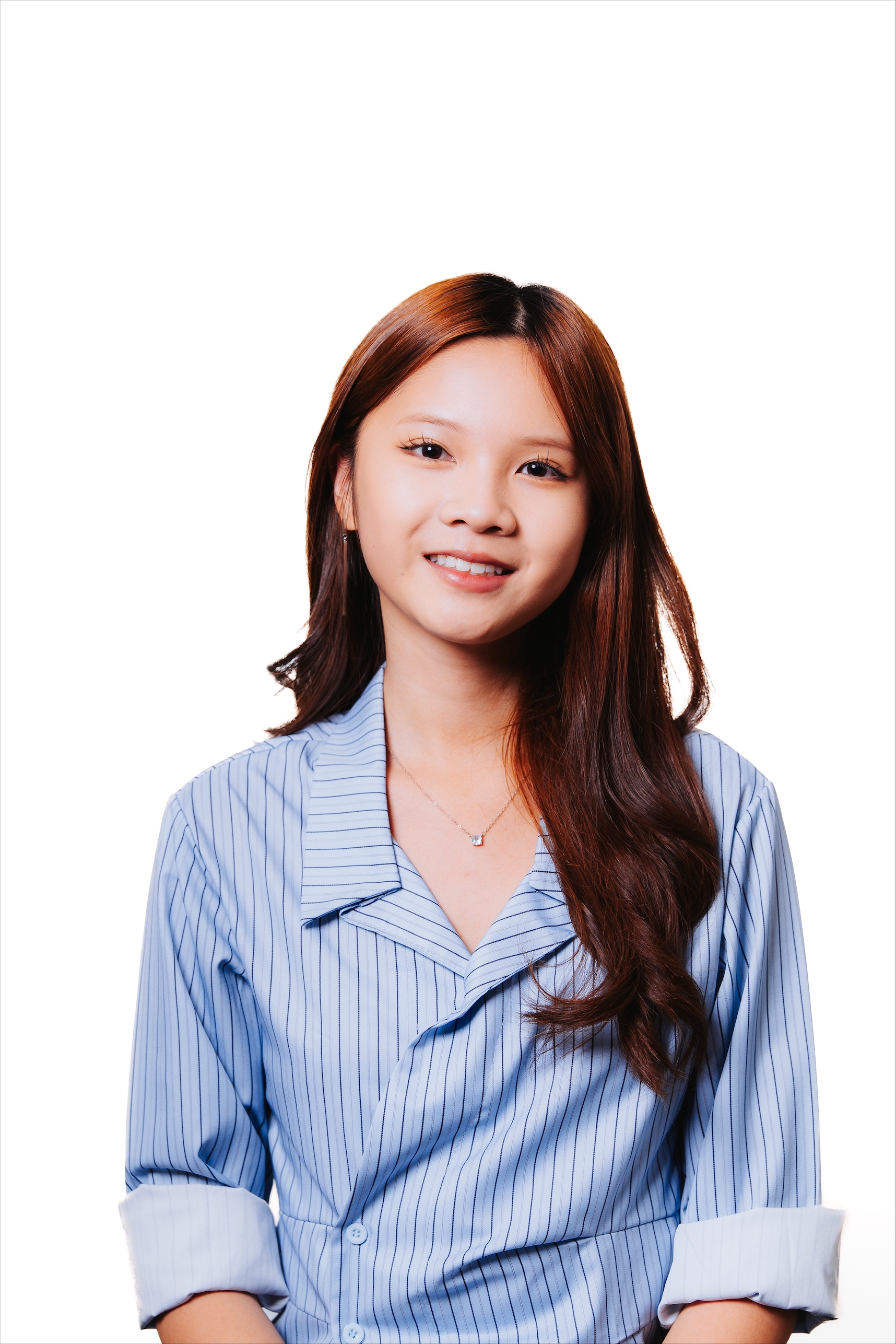 Color portrait of NSF Graduate Research Fellow Angela Le, wearing a light blue dress shirt with dark blue vertical stripes, in front of a white background.