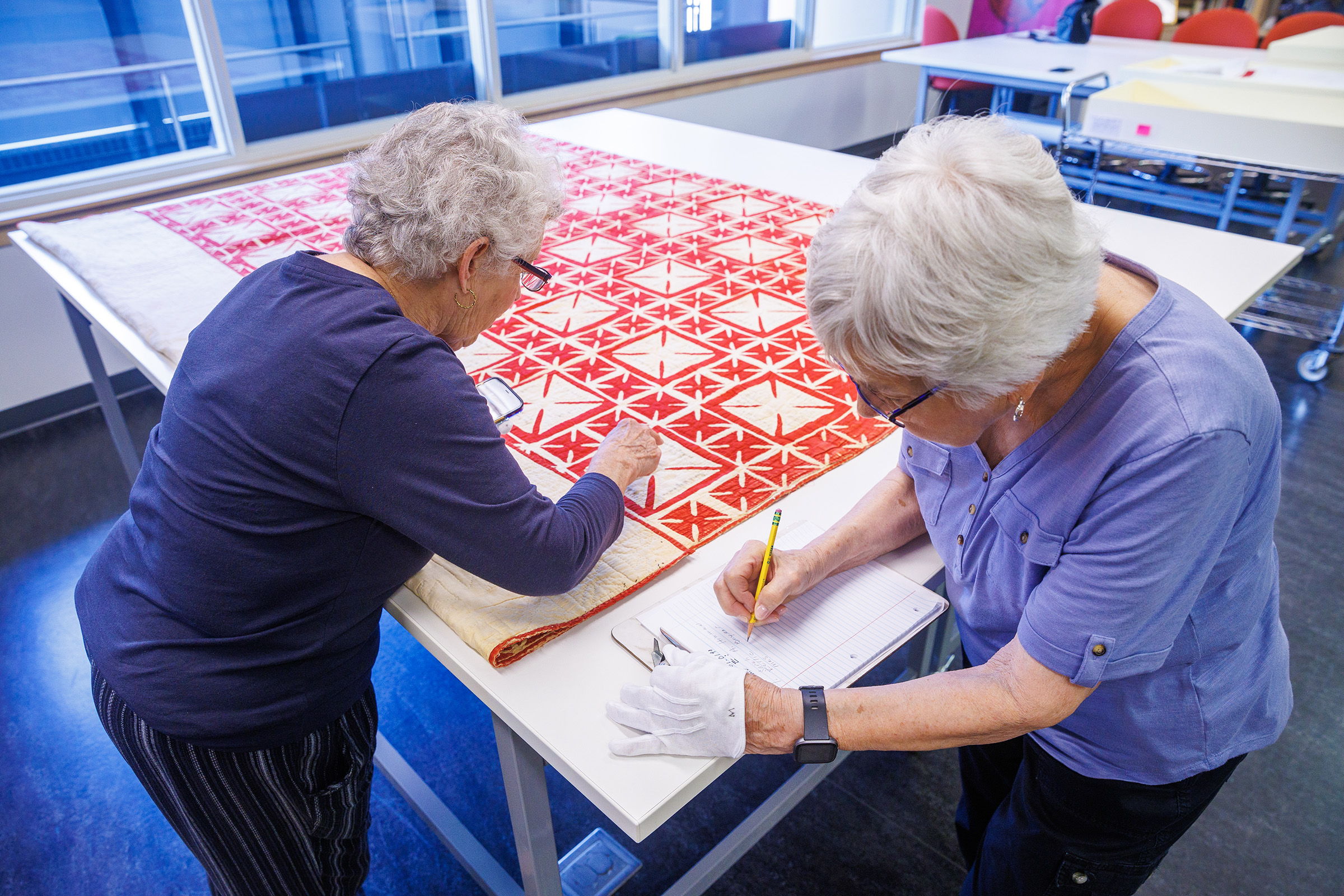 Carolyn Kitterer (left) reads the names off of the quilt while Susan Macy writes them down. (Kristen Labadie/University Communication and Marketing)