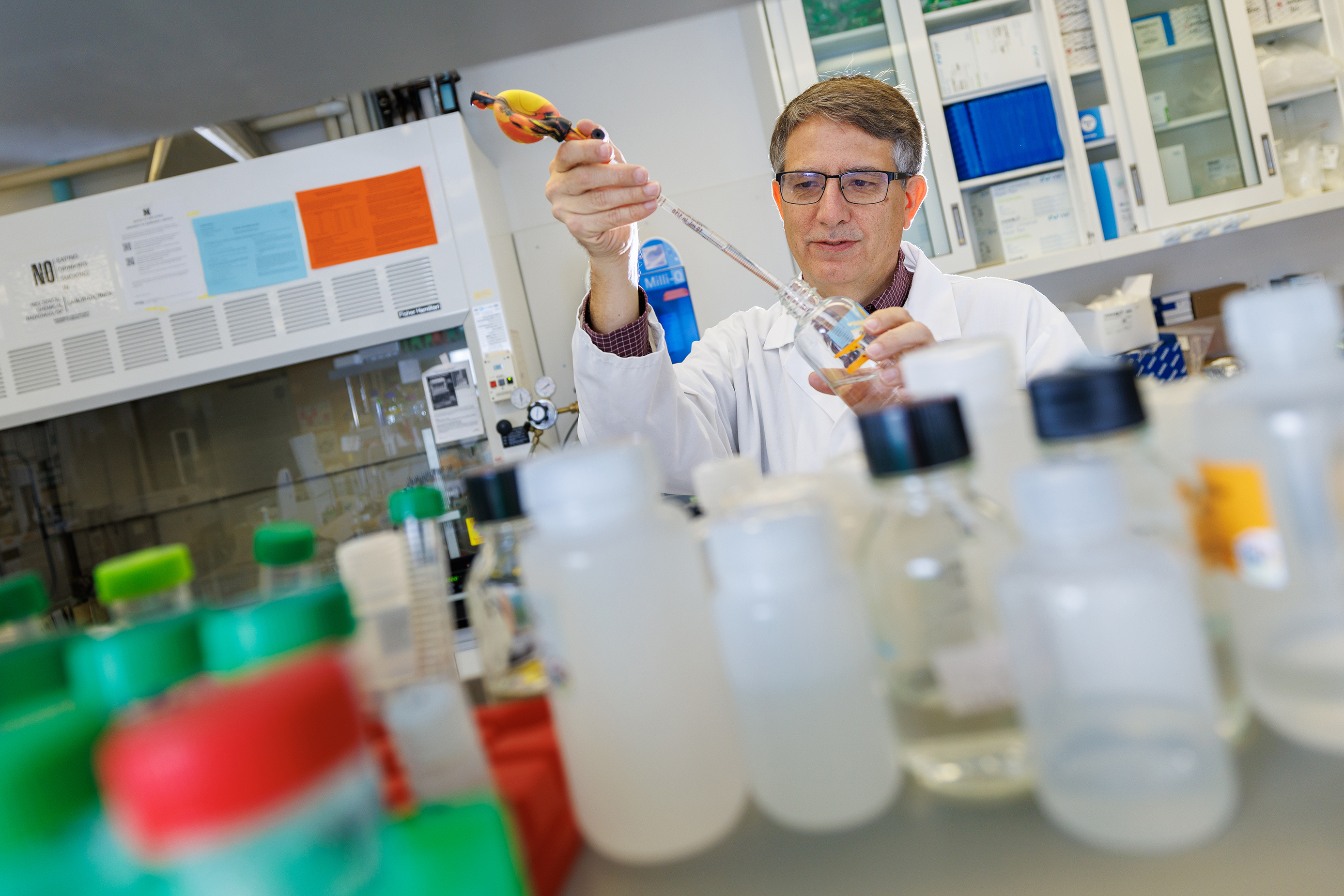 Edgar Cahoon stands inside his laboratory in Beadle Hall at the University of Nebraska–Lincoln. Scientific equipment and research materials are visible in the lab around him.