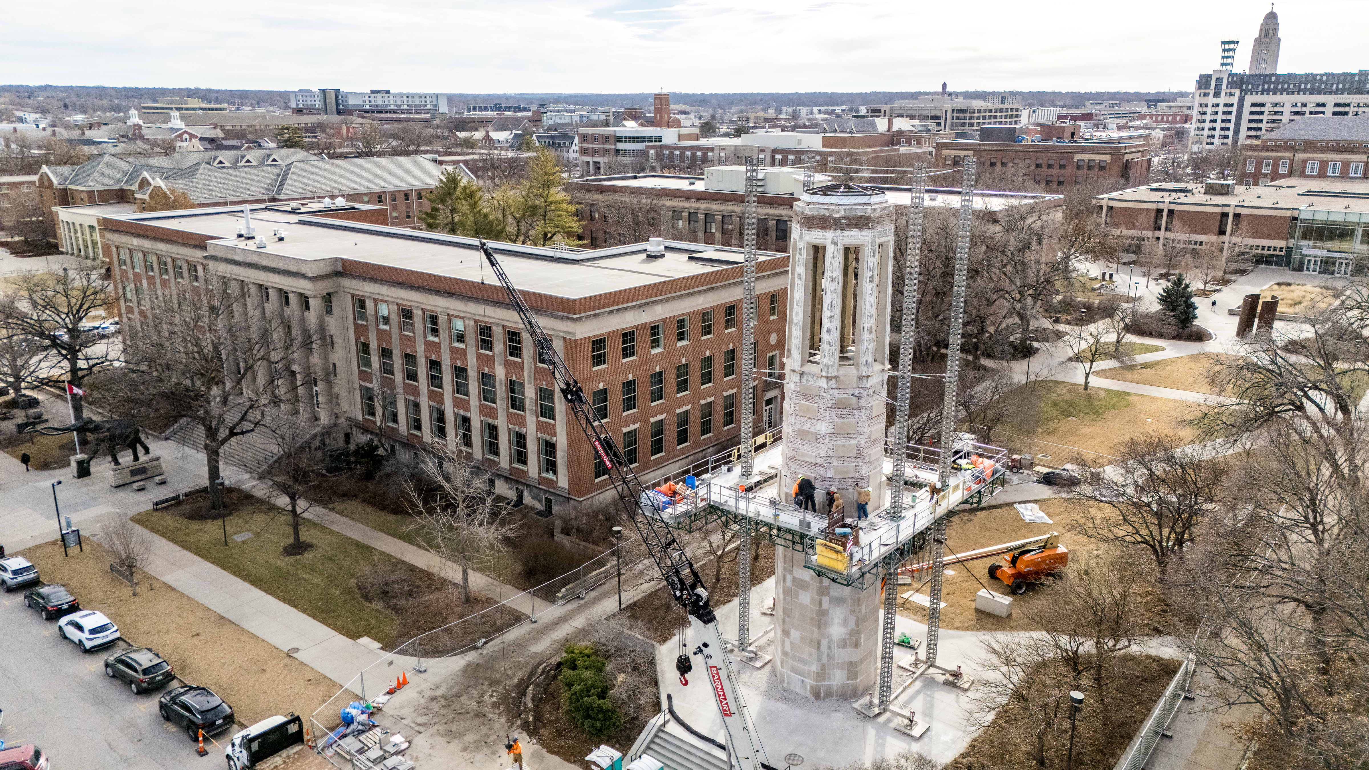 Crews on scaffolding replace brick around Mueller Tower.