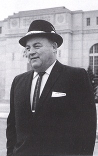 Bob Devaney standing in front of Memorial Stadium