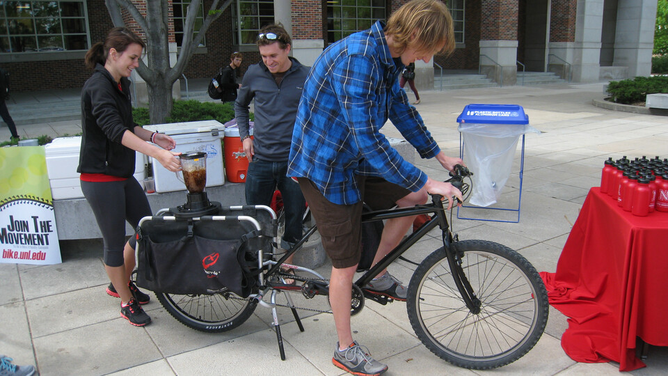 A person rides a bike that powers a blender that makes a smoothie during a past year's Bike Fest