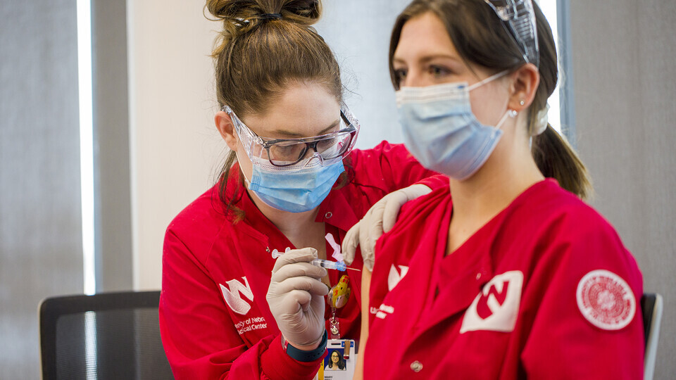Mary Neill vaccinates Aubrey Busteed at a College of Nursing vaccination clinic on Jan. 29. 