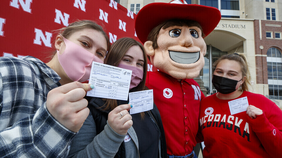 Students took time to pose with Herbie Husker after getting vaccinated in the on-campus Pfizer vaccination clinic on April 20. [Craig Chandler | University Communication]