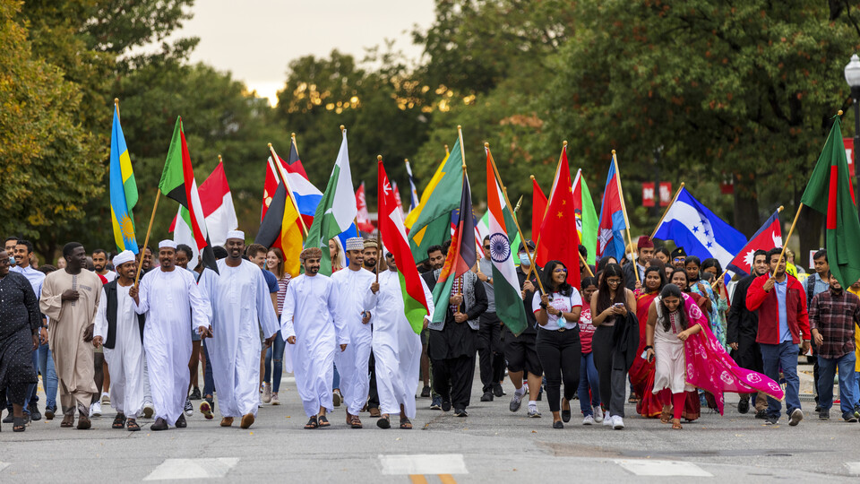 International students carry flags in the Homecoming parade