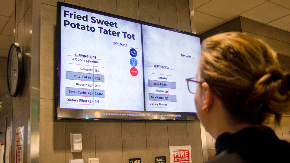 Customer views the menu board in the Cather Dining Center.