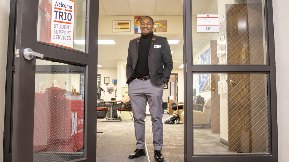 Cameron Woodard, Director of TRIO Programs at UNL, poses at the doors of the TRIO offices. 