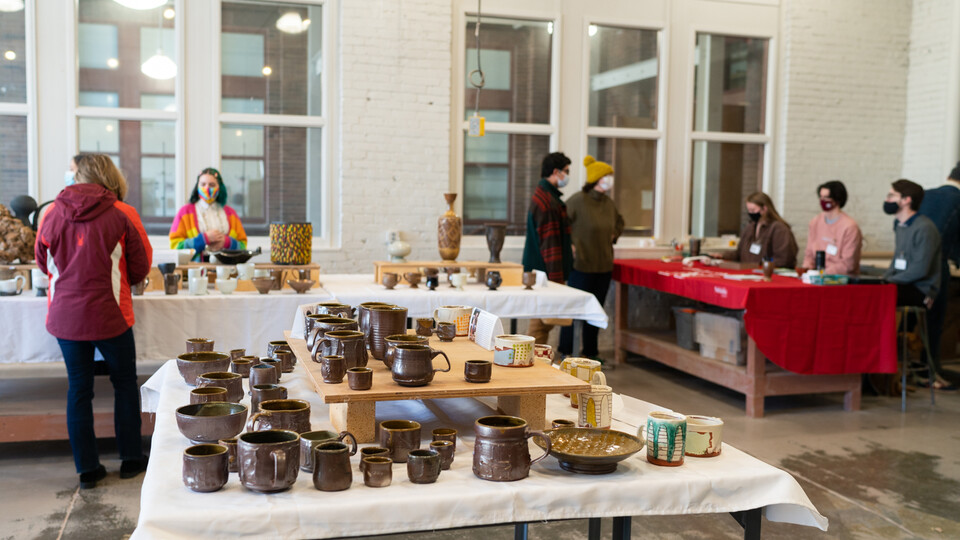 People browse work available for sale at last year’s Clay Club sale. This year’s sales, featuring work made by graduate and undergraduate students in ceramics, photography, printmaking and painting, are Dec. 9-10 in Richards Hall. Photo by Eddy Aldana.  