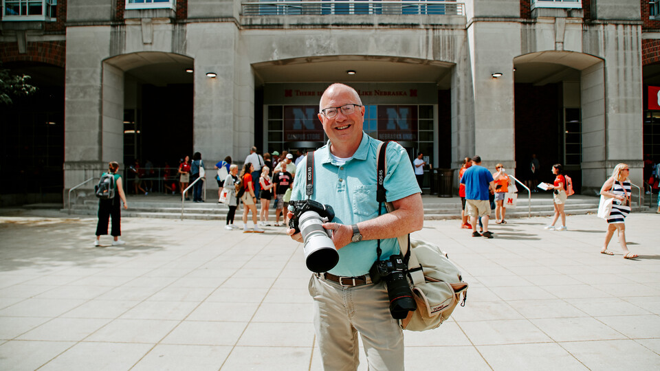 Chandler with his camera equipment, seen here photographing New Student Enrollment on city campus.