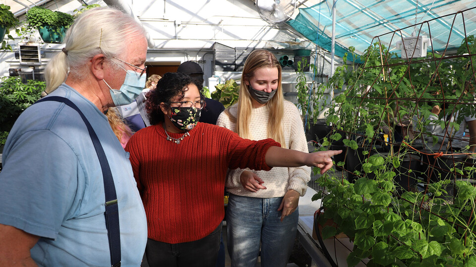 Senior horticulture majors Deanna Montanez Mendoza (second from left) and Jenna Lukas (right) answer Gary Bell’s questions during the Horticulture 307 Hydroponics for Growing Populations class open house Nov. 23, 2021.