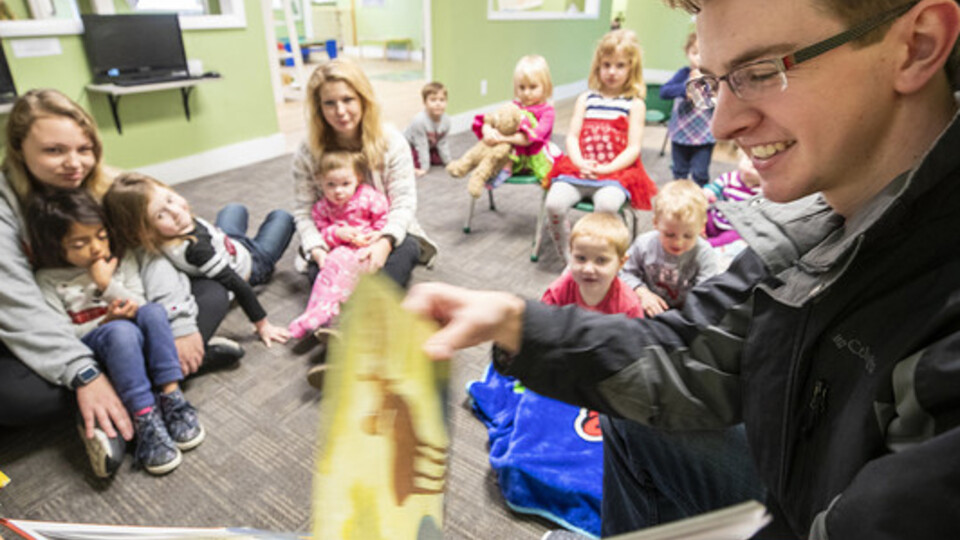 Thomas Kerr, a senior accounting major from Hastings, reads to children at the Foundations Progressive Learning Center during the Husker Reading Challenge.