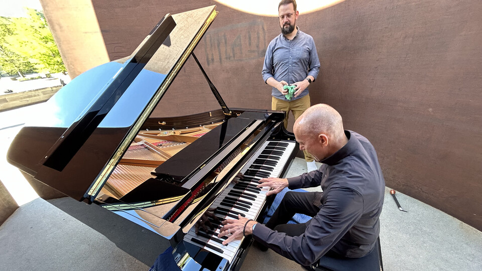 Paul Barnes, professor of piano in the Glenn Korff School of Music, practices before his performance of composer Philip Glass’ works inside “Greenpoint” sculpture on May 1. Adam Schulte-Bukowinski (standing), piano technician for the School of Music, helped tune the piano prior to the performance. Learn more at https://go.unl.edu/k4cv.