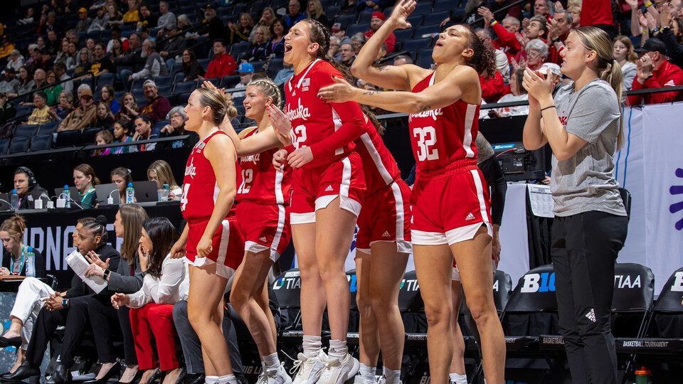 Members of the women's basketball team celebrate from the sidelines of Pinnacle Bank Arena