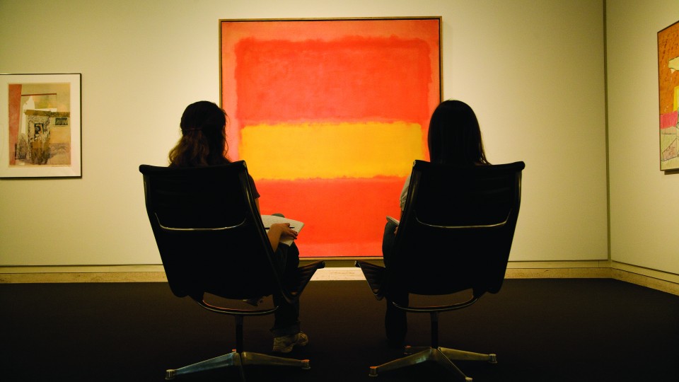 Two young women examine Mark Rothko's painting, "The Yellow Band," in the Sheldon Museum of Art.