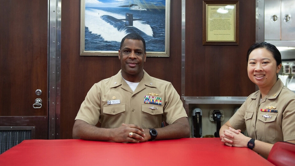 Commanding Officer Cmdr. Vance Scott (center) and Supply Officer Lt. j.g. Jenny Li pose for a photo in the USS Nebraska’s wardroom. The Ohio-class ballistic missile submarine crew has named its working and living spaces after communities throughout the state of Nebraska. USS Nebraska is one of eight ballistic-missile submarines stationed at Naval Base Kitsap - Bangor.