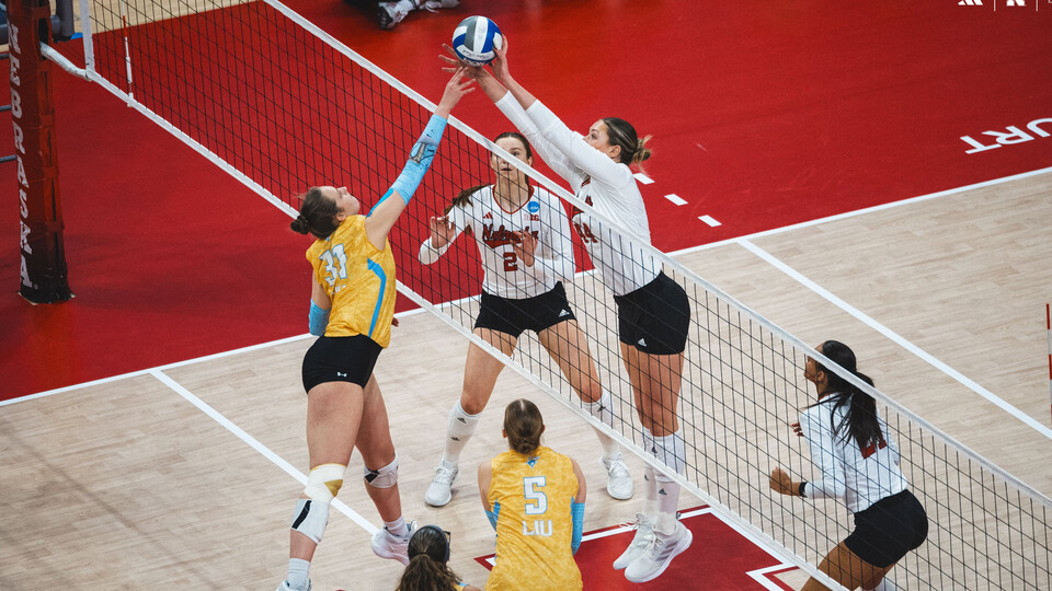 Maggie Mendelson rises above the net for a block during Nebraska volleyball's win over Long Island University