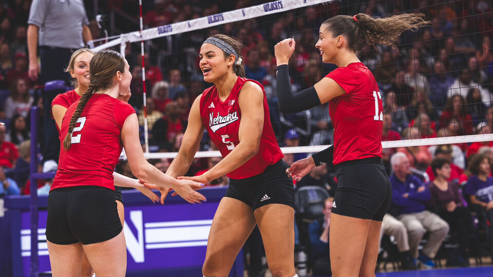 Husker volleyball players celebrate during a match with Northwestern