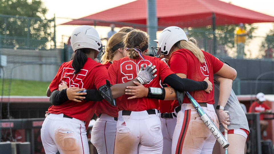 Members of the Husker softball team huddle up during a scrimmage