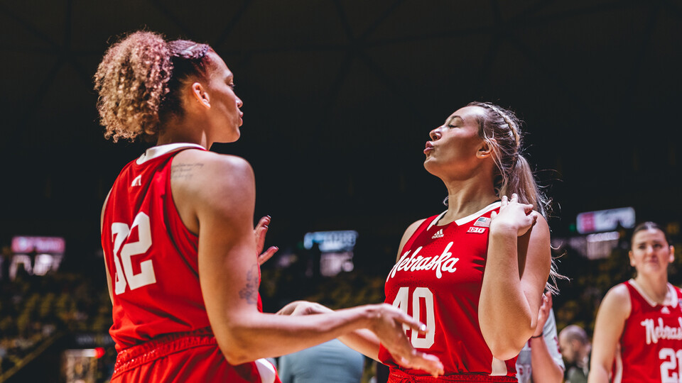 Husker basketball players Kendall Coley and Alexis Markowski make exaggerated kissy-faces while celebrating on the court