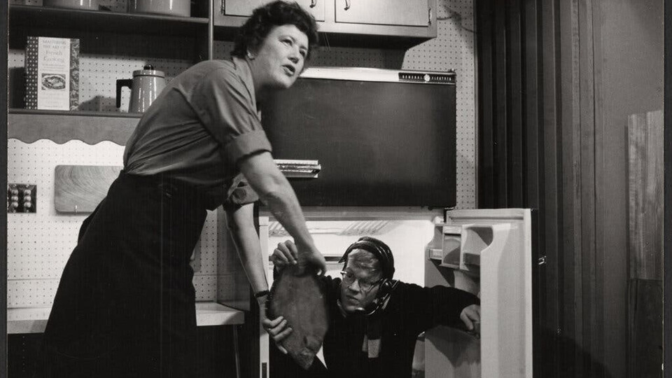 Julia Child being handed some food during her TV show in "Julia."