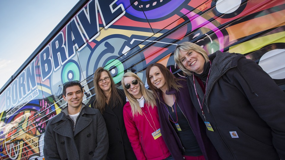 Susan Swearer (right) poses with coworkers and graduate students in front of the Born Brave Bus during its Kansas City concert stop on Feb. 4, 2013. Swearer, a leading national researcher on bullying, also guided a research board to advise Lady Gaga's Born This Way Foundation on its youth empowerment and tolerance programs.