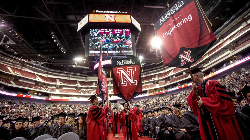 College banners stream onto floor during UNL commencement exercises in December 2013.
