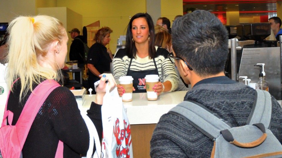 Emily Carder, a junior marketing major, serves coffee in the Nebraska Union's redesigned Caffina Café. The space, along with an updated welcome desk and Runza restaurant, opened Jan. 13.