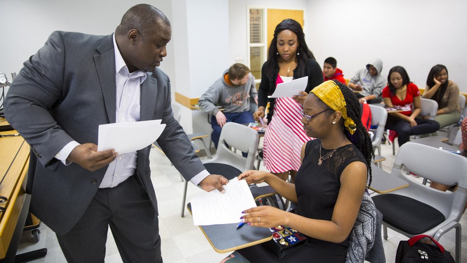 UNL's Robert Perry hands out papers during a freshman seminar in an Ethics 100 course. More than 4,500 UNL students were named to the Dean's List/Honor Roll for the fall 2014 semester. 
