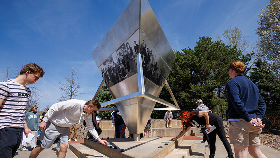Students placing rocks on Nebraska Holocaust Memorial