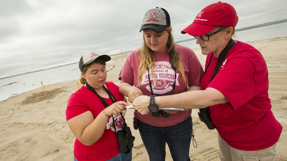 Mary Bomberger Brown (right) discusses Piping Plover habitat with students (left) Peyton Burt and Jessica Tramp at Lake McConaughy.