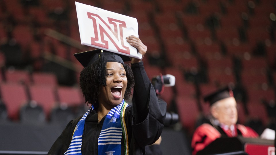Cierra Tooley gestures to her cheering section of more than 30 family and friends as she celebrates her bachelor of science in forensic science degree during the undergraduate commencement ceremony Dec. 19 at Pinnacle Bank Arena. Tooley said she is the first university graduate in her family.