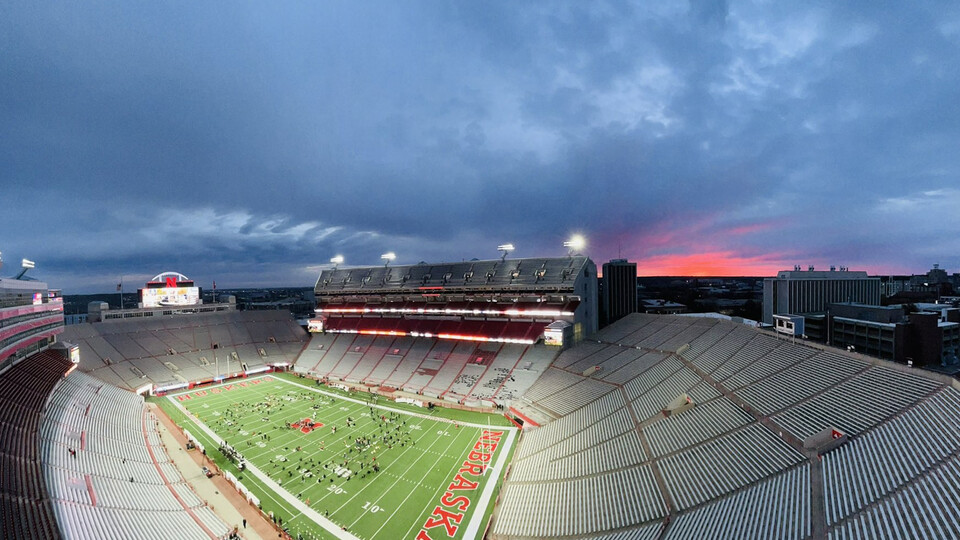 An interior shot of Memorial Stadium with the sun rising behind it