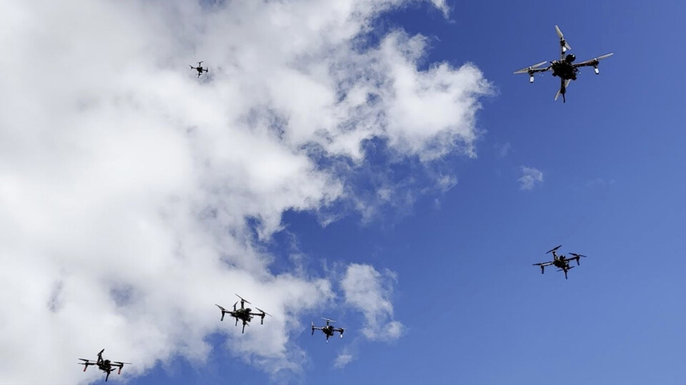 Swarm of drones against sky
